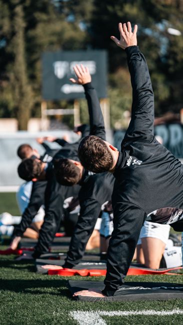 planning_entrainement_sport_semaine_a_group_of_athletes_perform_stretching_exerc